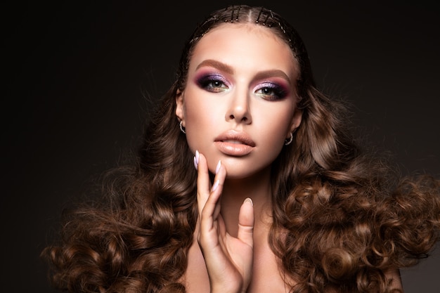 Beautiful young brunette with make up and curly hair