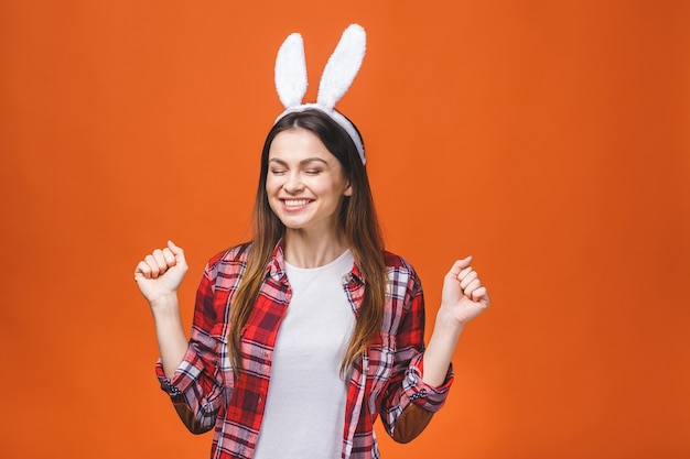 Beautiful young brunette woman in bunny ears looking at camera