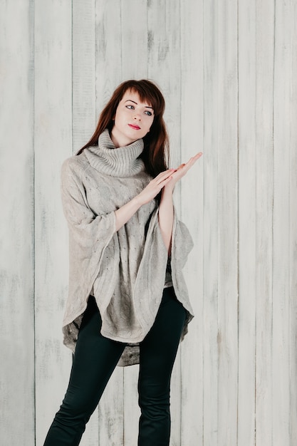 beautiful young brunette woman in gray pullover looking sideway thoughtfullyBody language