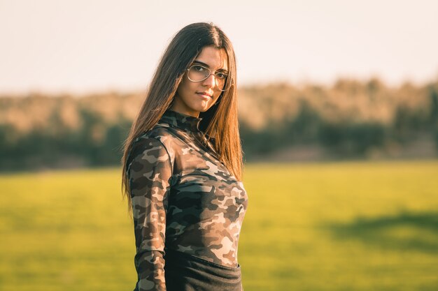 Beautiful young brunette woman with long hair in meadow in summer