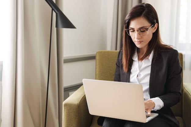 beautiful young business woman in formal wear clothes indoors at home work with laptop computer.