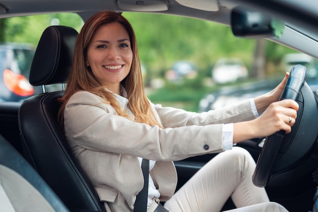 Beautiful young businesswoman driving car.