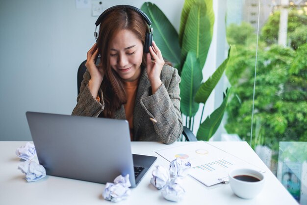 Una bellissima giovane donna d'affari si diverte ad ascoltare musica per alleviare lo stress sul lavoro