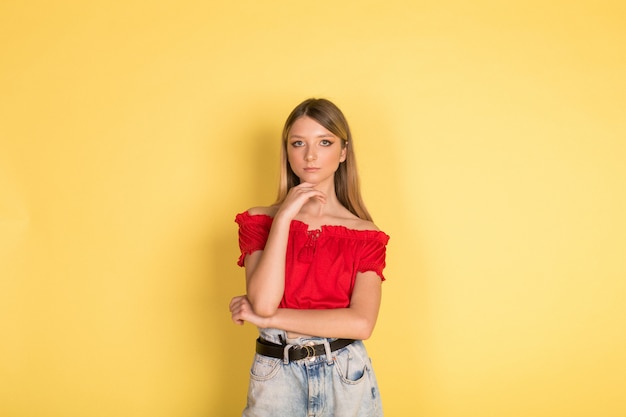 Beautiful young caucasian beauty blondie girl portrait on yellow wall