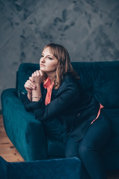 Beautiful young caucasian European woman sitting in an armchair