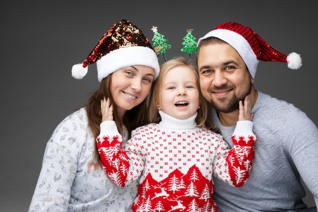 3人の美しい若い白人家族が一緒にクリスマスの時間を過ごします