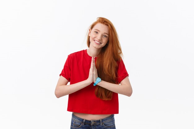 Beautiful young caucasian female, holding hands in namaste or prayer, keeping eyes closed while practicing yoga.