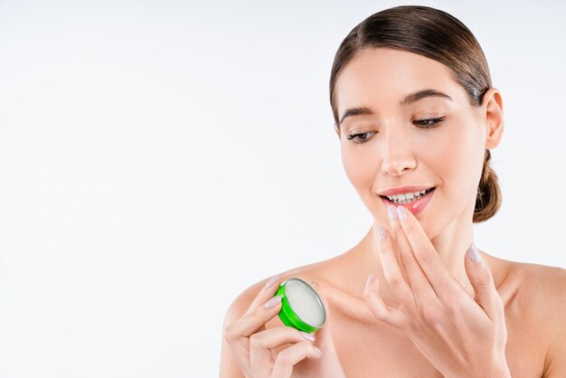 Beautiful young caucasian woman applying lip balm care make up concept
