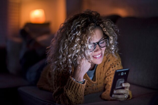 Bella giovane donna caucasica a casa che usa la tecnologia per rimanere aggiornata