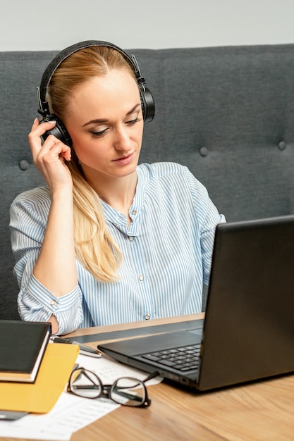 Beautiful young caucasian woman with headphones and laptop sitting at the table in a cafe