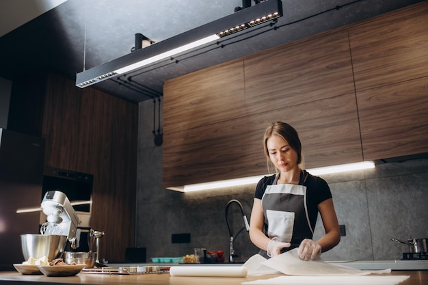 Beautiful young chef decorating delicious dessert