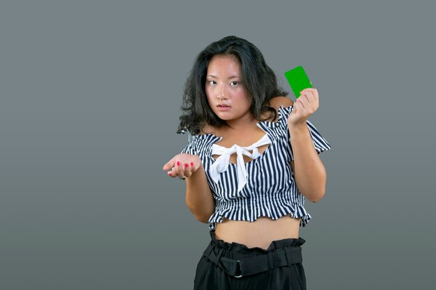 Beautiful young chinese woman with card in hand and graceful expression of hesitation