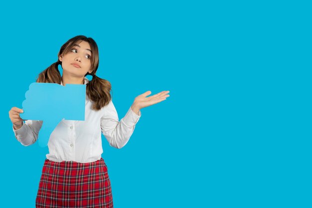 Beautiful young college lady holding unlike sign and point hand away. High quality photo