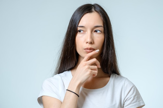 Beautiful young confident woman with serious expression isolated on gray