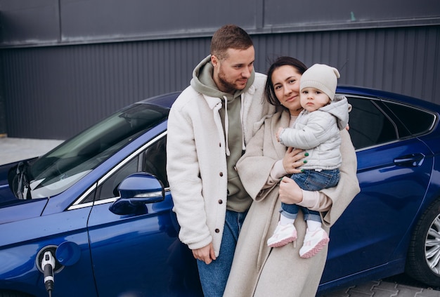 Beautiful young couple charges an electric car