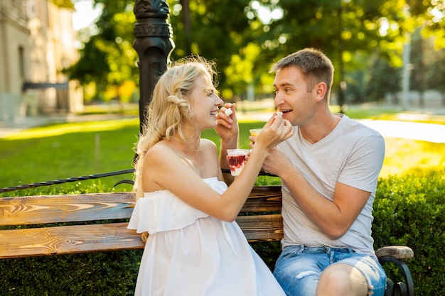 Beautiful young couple eating ice-cream on the street