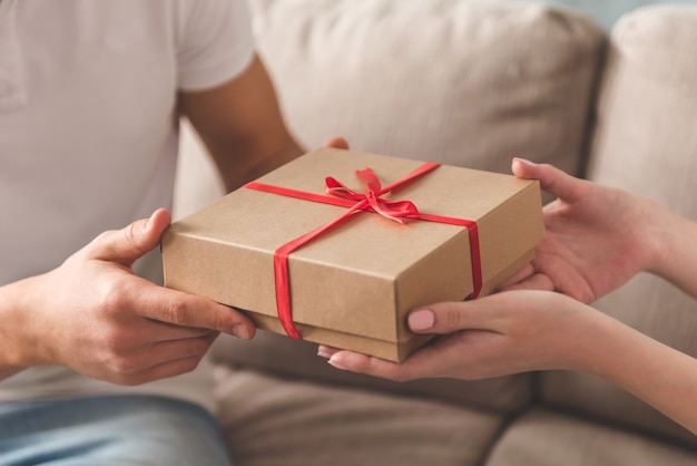 beautiful young couple holding a gift box