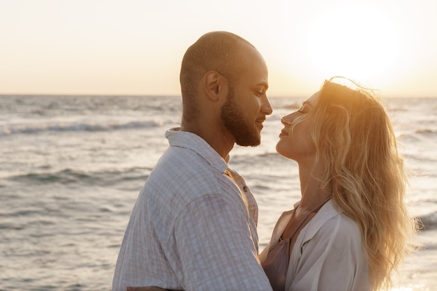 Beautiful young couple hugging on the beach by the water