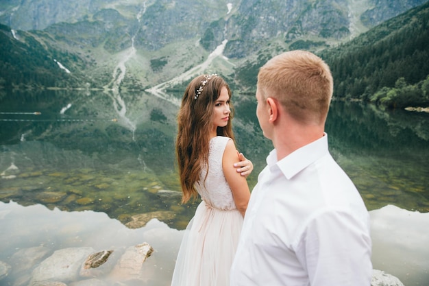 A beautiful young couple at the lake in Tatra mountains in Poland Morskie Oko