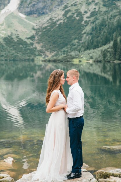 A beautiful young couple at the lake in Tatra mountains in Poland Morskie Oko