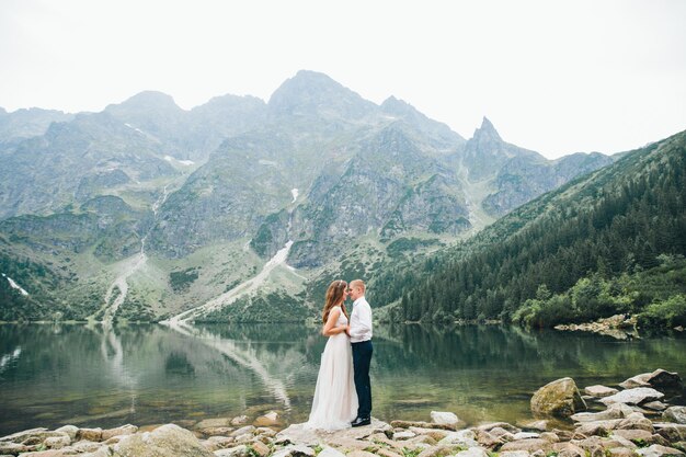 A beautiful young couple at the lake in Tatra mountains in Poland Morskie Oko