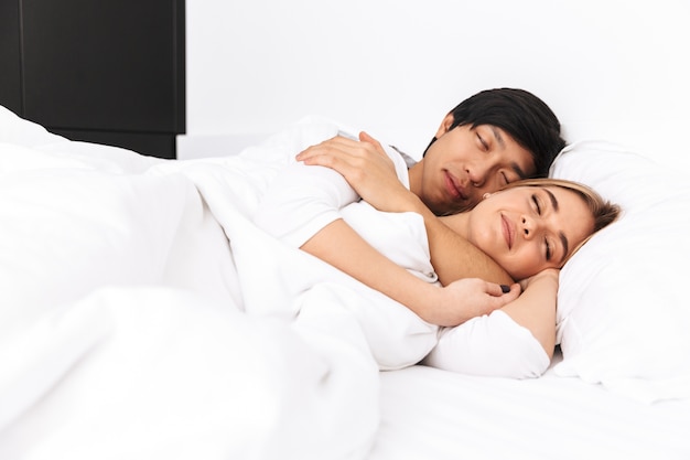 Beautiful young couple, laying in bed, sleeping