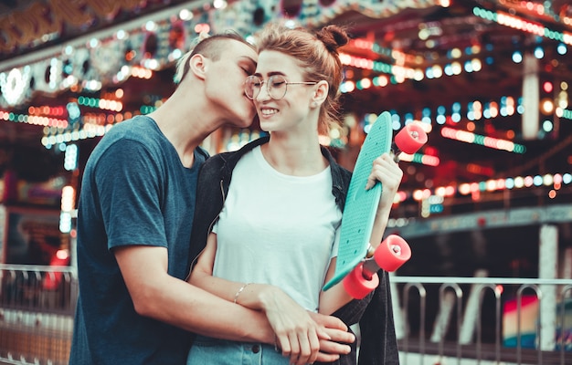 Beautiful, young couple in love having fun at amusement park.