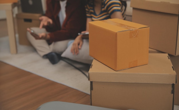 Beautiful young couple in love having fun unpacking things from cardboard boxes while moving in together in their new apartment