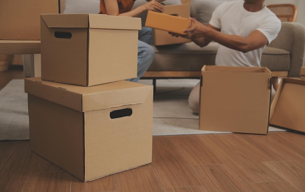 Beautiful young couple in love having fun unpacking things from cardboard boxes while moving in together in their new apartment