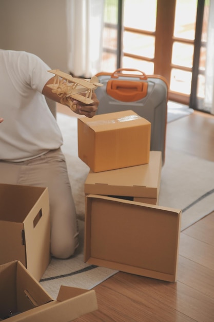 Beautiful young couple in love having fun unpacking things from cardboard boxes while moving in together in their new apartment