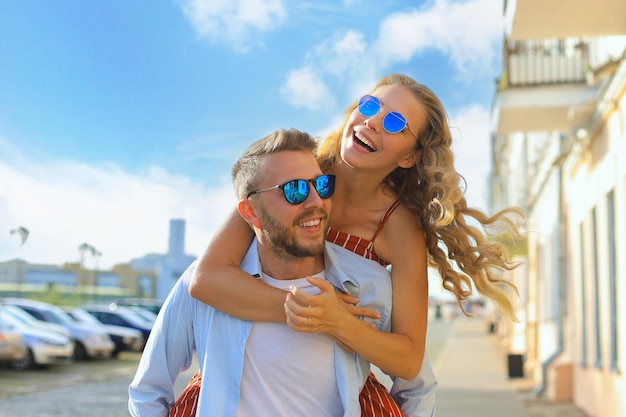 Beautiful young couple in love walking outdoors at the city street hugging