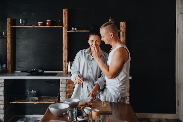 Beautiful young couple preparing a healthy meal together while spending free time at home