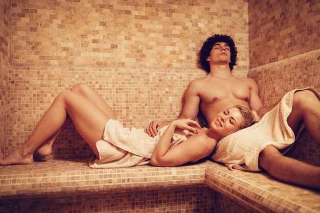 Beautiful young couple relaxing and enjoying in the steam bathroom at the spa centre.