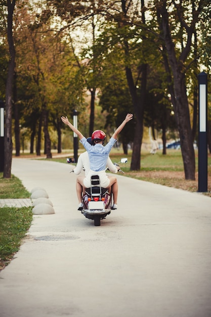 Photo beautiful young couple riding scooter