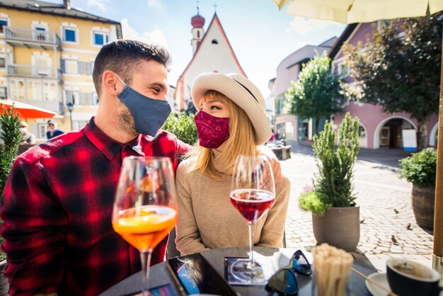 Beautiful young couple sitting in a bar restaurant and having a drink  Two lovers dating outdoors