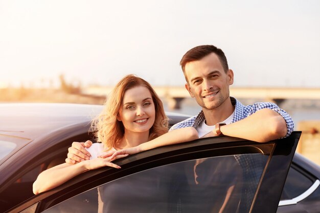 Photo beautiful young couple standing near car