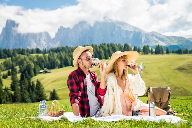 Beautiful young couple travelling and doing a picnic in the Dolomites, Italy