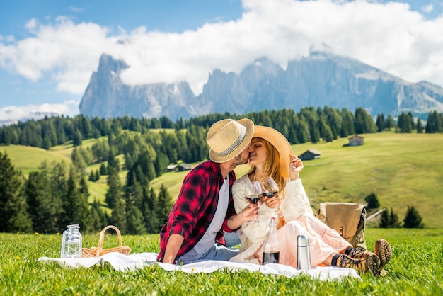 Beautiful young couple travelling and doing a picnic in the Dolomites, Italy