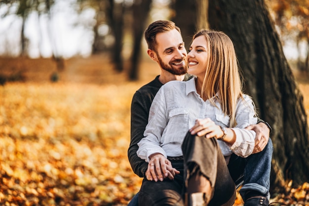 Beautiful young couple walking in the autumn park on a sunny day