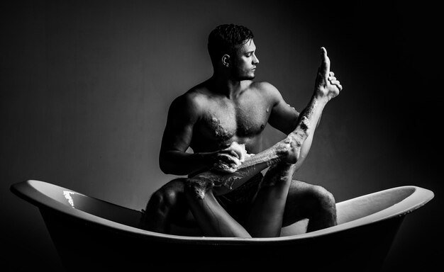 Photo beautiful young couple women with long legs sitting in bath tub with muscular man young woman relaxi