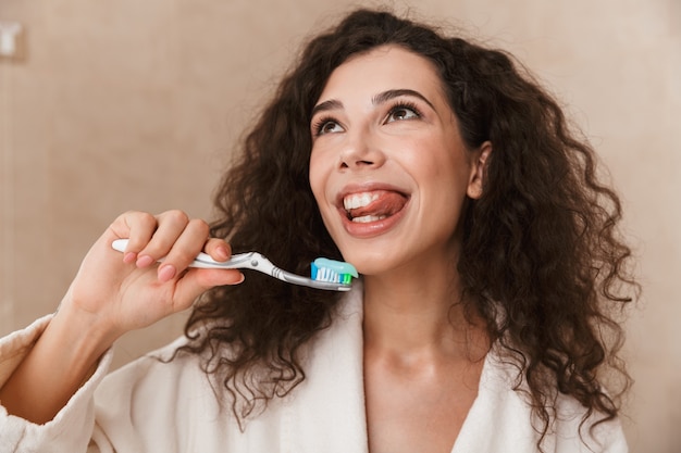 Beautiful young cute woman in bathroom brushing cleaning her teeth.