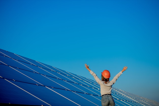 Красивый молодой инженер, стоящий возле солнечных батарей на открытом воздухе