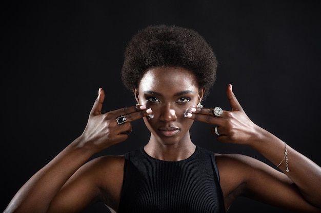 Beautiful young ethnic african american black woman applying moisturizer white cream on her face