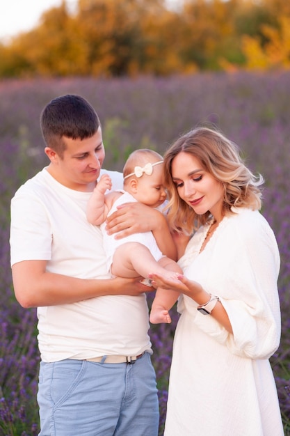 Beautiful young family on purple flower lavender field. Family vacation