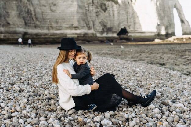 A beautiful young family on the sandy shore of the ocean relaxing and have a fun