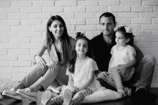 Beautiful young family with daughters at a photo shoot in a white studio