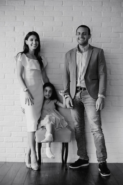 Beautiful young family with daughters at a photo shoot in a white studio