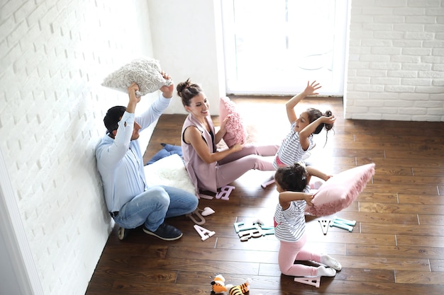 Beautiful young family with daughters at a photo shoot in a white studio