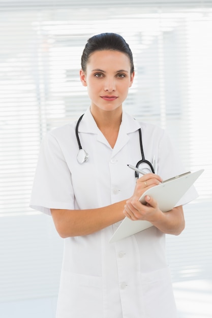 Beautiful young female doctor with clipboard