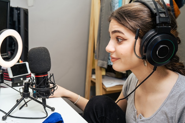 beautiful young female influencer streaming smiling and talking to her followers online. new technologies, communication, social media, fun, online games.
